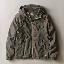 Load image into Gallery viewer, An olive green hooded utility jacket with a front zipper, flap chest pocket, and two large front hand pockets, laid flat against a neutral beige background.