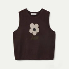 Load image into Gallery viewer, A sleeveless dark brown knit sweater vest featuring a large cream-colored flower with a green stem motif on the front, displayed flat against a light off-white background.
