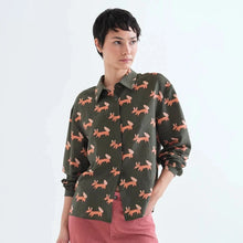 Load image into Gallery viewer, A model wearing a dark olive green button-up shirt with an all-over orange fox print, paired with dusty rose trousers, against a plain white studio background.
